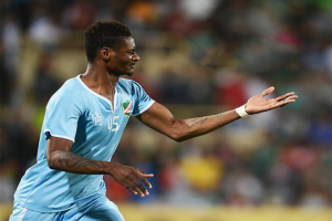 Ein Fussballspieler in einem blauen Trikot feiert nach einem Tor mit ausgebreiteten Armen