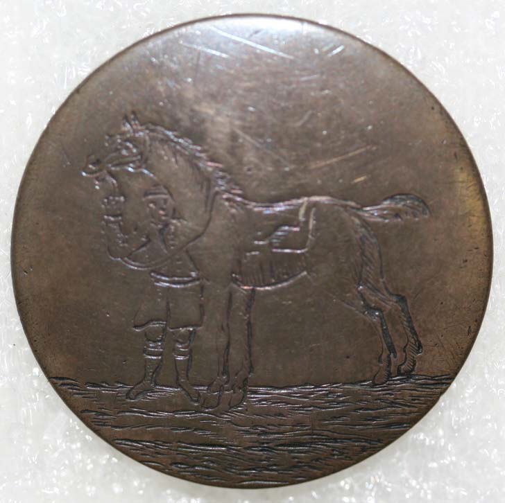 Bronzemedaille mit einer detaillierten Gravur eines Pferdes und Reiters vor einem weißen Hintergrund.