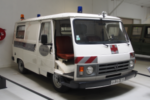 Ein Rettungswagen innerhalb eines Gebäudes geparkt mit einem Feuerlöscher an der Wand links.