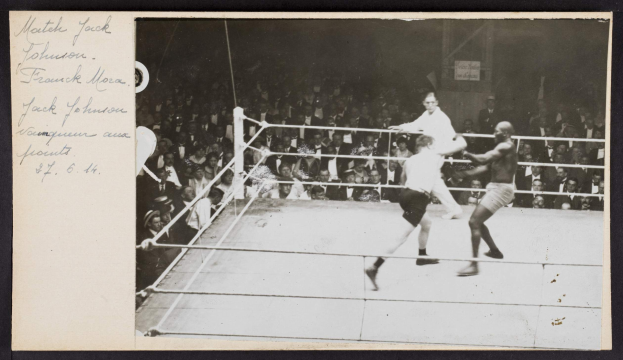 Schwarzes und weißes Foto von zwei Boxern in einem Ring, beschriftet mit 'Jack Johnson vs Frank Morgan', mit Zuschauern im Hintergrund.