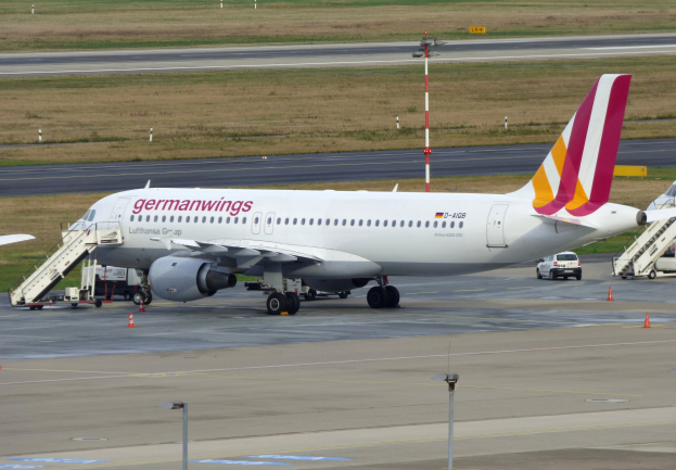 Germanwings Airbus A320-200 auf dem Frankfurt Airport mit Bodenfahrzeugen, Verkehrskegeln, Versorgungsmasten und Grünfläche im Hintergrund.