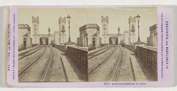 Schwarz-weiß-Stereoskopiebild einer Eisenbahnbrücke in Köln, Deutschland, mit Eisenbahnschienen, Mauern, Pfählen, Statuen, Himmel und Text.
