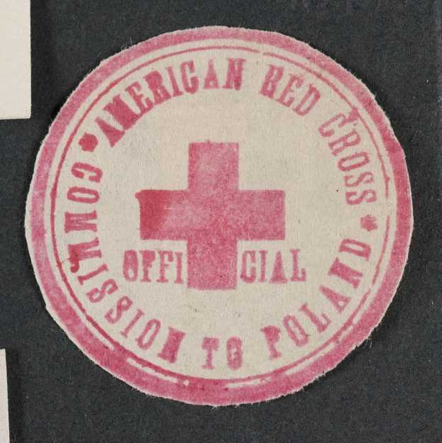 Rotes Kreuz-Siegel auf schwarzer Oberfläche mit dem Text "American Red Cross Commission to Poland".