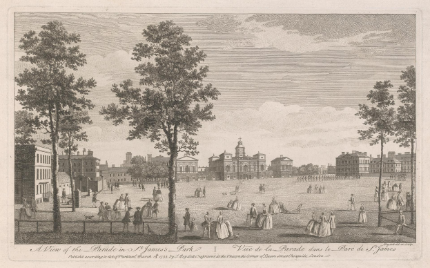 Eine Gruppe von Menschen, die während eines Umzugs in St. James Park stehen und sitzen, mit Bäumen und Gebäuden im Hintergrund bei einem bewölkten Himmel.