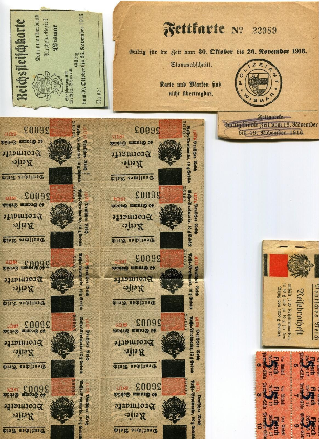 Alte deutsche Fahrkarten und Marken auf einem weißen Hintergrund, einige mit gedrucktem Text und Zahlen, zeigen Spuren von Abnutzung.