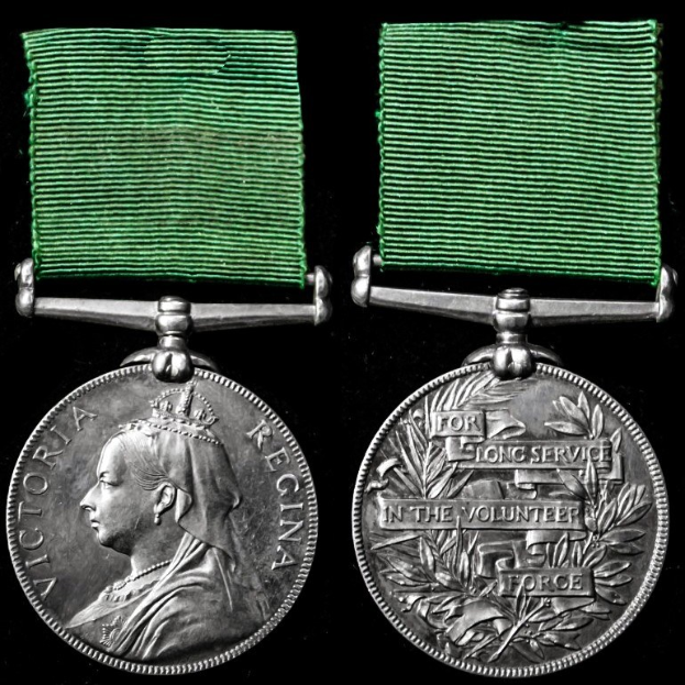 Zwei silberne Medaillen mit grünen Bändern, eine mit einer Personendarstellung und die andere mit eingravierter Schrift, vor schwarzem Hintergrund, wahrscheinlich aus dem Langgedientem in der Freiwilligen Force.