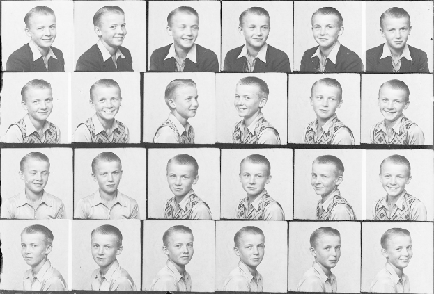 Ein Schwarz-Weiß-Foto eines strahlenden jungen Jungen mit ordentlich gekämmtem Haar und leuchtenden, fröhlichen Augen.