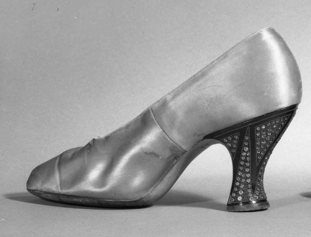Schwarzes und weißes Foto eines Paares hochhackiger Damenschuhe aus den 1930er Jahren aus glänzendem Material.