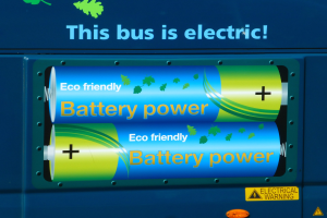 Blauer Elektrobus mit "Dieser Bus ist elektrisch"-Schriftzug und zwei sichtbaren Seitenspeichern.